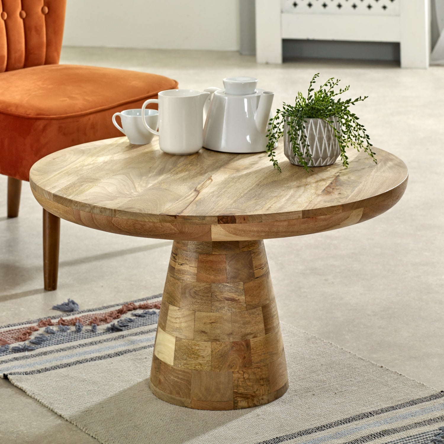 Merlin Mango Wooden Round Coffee Table Mushroom Style Wooden round table with decorative items in a living room setting