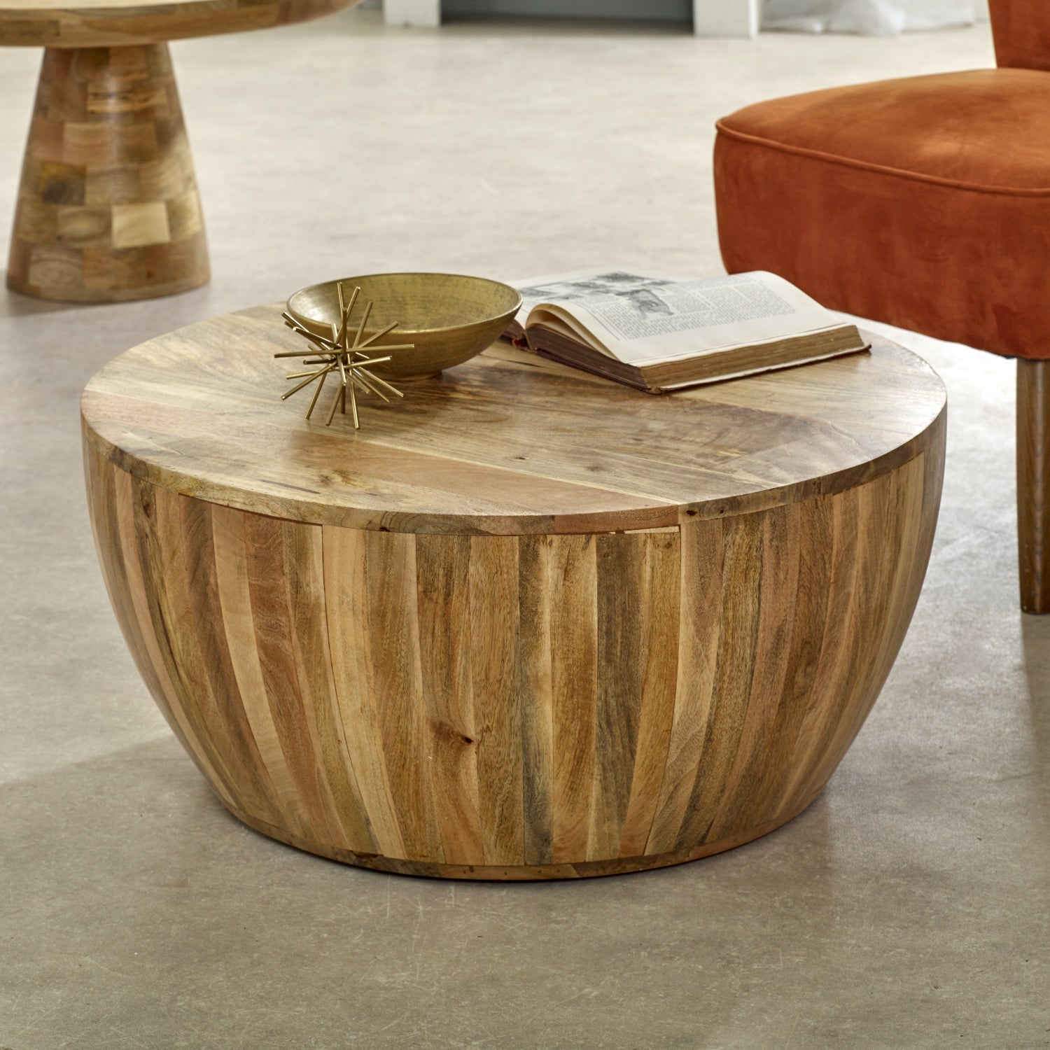 Merlin Mango Wooden Drum Coffee Table Wooden coffee table with decorative items in a room setting