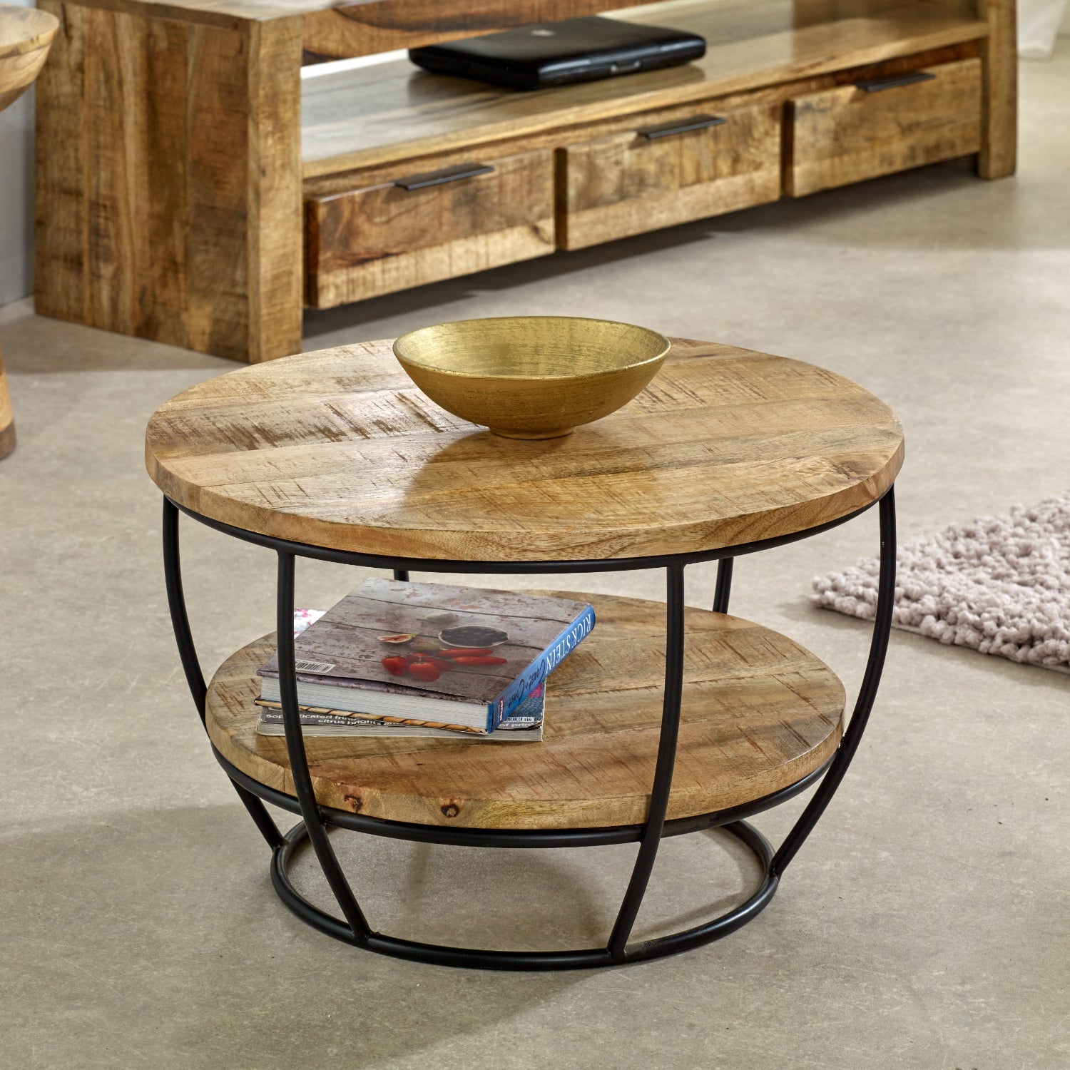Merlin Mango Wooden & Metal Coffee Table With Shelf Round wooden coffee table with metal frame in a living room setting